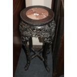 A Chinese carved hardwood jardiniere stand with circular marble top and pierced floral decoration,