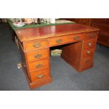 A Victorian mahogany pedestal desk with rectangular top above an arrangement of nine drawers, on