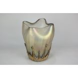 A Loetz style iridescent glass vase with scalloped rim and applied gilded decoration to the base,