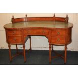 An Edwardian satinwood kidney shaped dressing table, the gallery and leather inset top over five