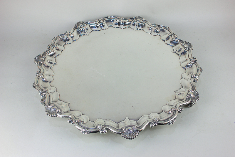 A large silver plated salver with cast scroll and shell border, on three scroll feet, 48cm