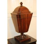 A George III mahogany urn shaped box with domed lid and finial (detached), tapered form with concave