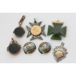 A gold mounted jade Maltese cross pendant, two gold swivel seals, two silver and gold pendants,