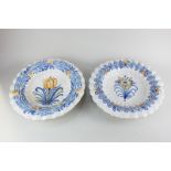 Two similar Delft pottery bowls, each with blue and yellow floral design and scalloped rims (a/f),