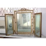 A gilt three panel dressing table mirror with ribbon surmount and egg and dart style moulded