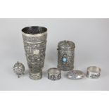 An Indian white metal cup with embossed design, a pot and cover, two trinket boxes, a pepper and two