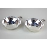 A pair of modern silver circular dishes with handles cast as serpents, maker Roberts and Dore,