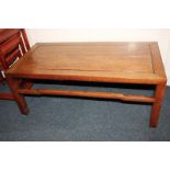 A Chinese hardwood coffee table with rectangular top on square notched legs with uniting