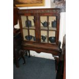 A Queen Anne style mahogany display cabinet with two glazed panel doors enclosing single shelf, on