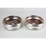 A pair of modern silver bottle coasters, maker Wakely and Wheeler, London 1984, with turned wooden