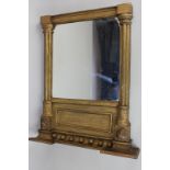 A Regency style gold painted wall mirror with moulded cornice above two lion masks, the mirror plate