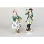 Two similar Sitzendorf porcelain figures of a lady flower seller and a boy with bugle, both in green
