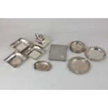 A George V silver table lighter and three matching silver square dishes with engraved initials and