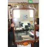 A George III mahogany fret cut wall mirror with scrolling gilt decoration and bird surmount,