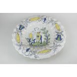 A Delft pottery polychrome bowl with scalloped rim, depicting a dog amongst foliage with floral