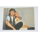 A photographic postcard signed in pen by Paul McCartney, depicting Paul and Linda McCartney, taken