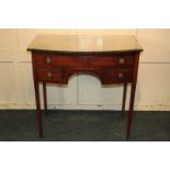 A mahogany kneehole side table with long drawer and two small drawers beneath, on square tapered