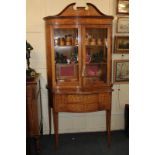 An Edwardian satinwood and marquetry display cabinet with broken arched pediment above two glazed