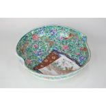 A Japanese porcelain plum shaped dish decorated in famille rose palette with panel of trees in a