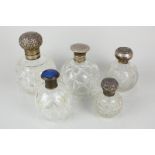 Five various cut glass globular scent bottles including four with silver tops and another with