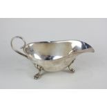 A George V silver sauce boat with scroll handle, on three paw feet, maker J B Chatterley, Birmingham