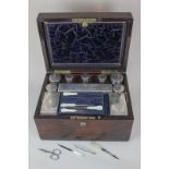 A Victorian rosewood dressing table box containing ten matched silver topped glass boxes and jars,