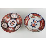 Two Japanese Imari porcelain bowls with scalloped rim and floral design, one marked to base, largest
