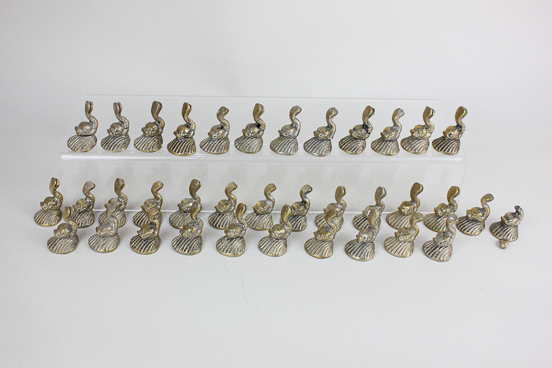 A set of thirty-six dolphin shaped brass menu holders on shell bases (one a/f)