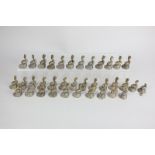 A set of thirty-six dolphin shaped brass menu holders on shell bases (one a/f)