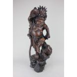 A Chinese carved hardwood figure of a deity holding aloft a coin, 64cm