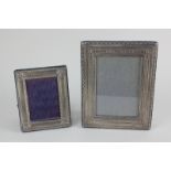 A modern silver photograph frame, rectangular shape with decorative border, blue cloth backing and