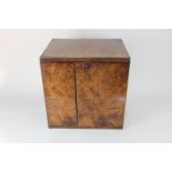 A brass bound walnut humidor table cabinet with flush handles, two rectangular doors enclosing three