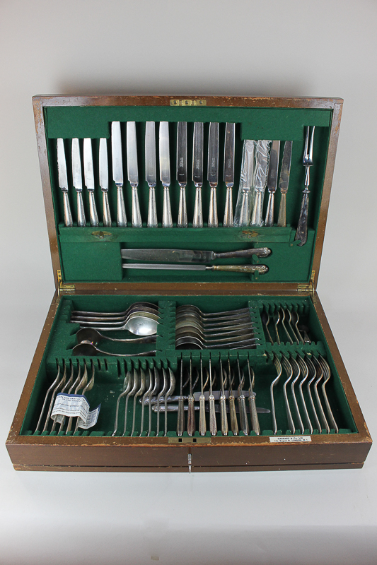 A part canteen of silver plated cutlery, assorted dinner forks, knives, spoons and servers in walnut