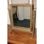 A giltwood and gesso framed rectangular dressing table mirror with scrolling foliate decoration in