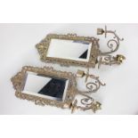 A pair of gilt metal girondelle wall mirrors, each with scrolling pierced frame, and two light