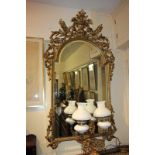 A Rococo style gilt wall mirror with scrolling pierced floral and foliate decorated frame and