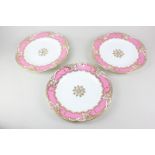 A set of three 19th century porcelain dessert plates with pink and gilt pierced borders, the bases