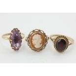 An amethyst ring, a garnet ring, a shell cameo ring, all in 9ct gold