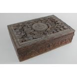 A heavily carved wooden box, possibly Indian, the hinged lid inscribed 'Tela Sparsimus', amongst