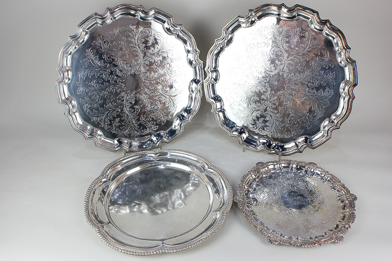 A pair of silver plated salvers with engraved decoration and piecrust borders, 37cm, another smaller