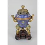 A Chinese brass and enamel incense burner, circular form with pierced cover cast with a recumbent