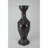 A Japanese bronzed metal baluster vase decorated in raised relief with birds amongst foliage,