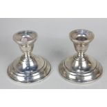 A pair of Sterling silver dwarf candlesticks, vase shaped sconces on loaded circular bases, marked