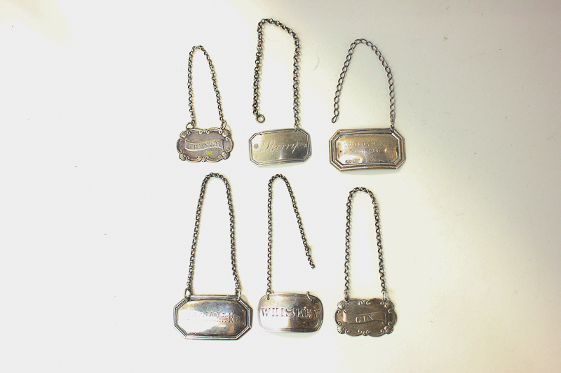 A collection of four various silver decanter labels, including two Victorian for whiskey and