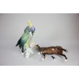 A Karl Ens porcelain model of a parakeet, 25cm high, together with a Beswick model of a horse (a/f)