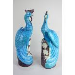 A pair of Chinese pottery Ho-Ho birds on pierced floral bases, in blue and brown glaze, 40cm high