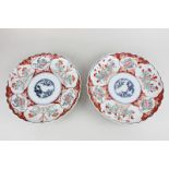 A pair of Japanese Imari porcelain plates with scalloped rims, depicting flowers and foliage, 22cm