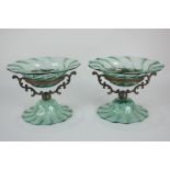 A pair of Victorian green glass sweets dishes with scrolling brass supports, 11cm high