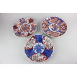 Three Japanese Imari porcelain plates with scalloped rims and floral designs, largest 22cm diameter