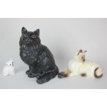 Three Beswick porcelain models of cats, including Siamese, lying facing left (No:1558B) in seal